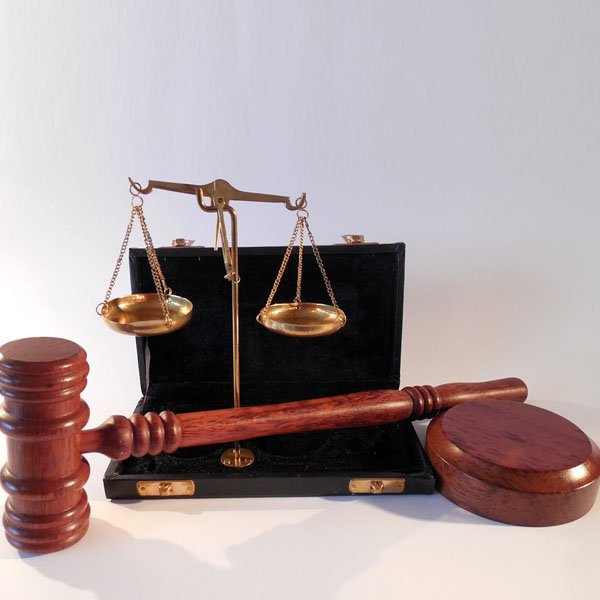 scales of justice and gavel and block sit against white background
