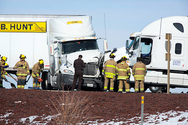 Firefighters and police officer on the scene of an accident between two big hauler trucks.