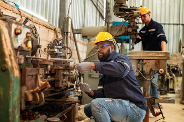 A factory worker changes the settings on a machine on the production line. 