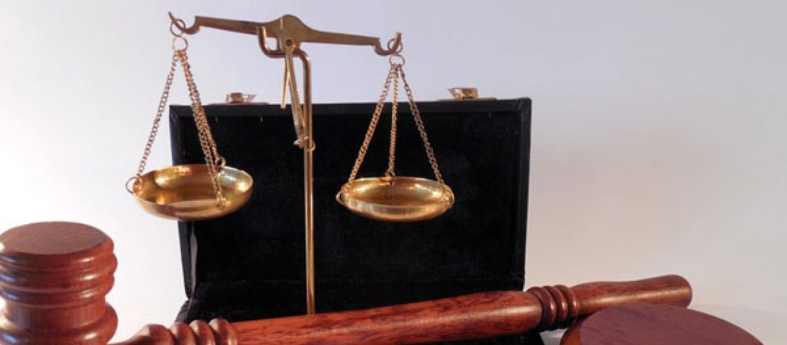 scales of justice and gavel and block sit against white background